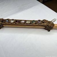 Full view of bamboo wall decor piece showing gemstones inset along top.