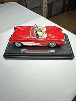 Top view of red 1957 Corvette model on display base showing full body and interior detail