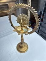 Front view showing full lamp with halo, peacock, dish and base