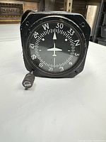 Front view of Cessna directional gyro showing compass card and push-cage knob