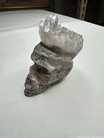 Front angled view showing skull carving and quartz points