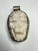Front view of carved skull pendant showing design details