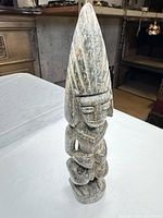 Front view of tall stone tribal figure showing overall form and condition