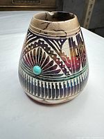 Front view showing painted feather motif, turquoise cabochon and overall form