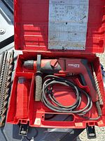 Drill, power cord, side handle and case interior