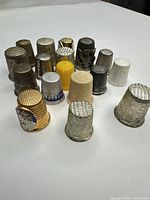 Group shot of all 17 metal thimbles standing on table