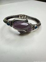Top view of bangle showing purple centerpiece and teal side stones