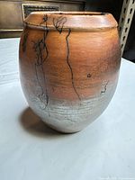 Side view showing brown-to-gray gradient glaze and black decorative lines