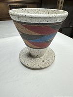 Full side view showing conical shape, multicolour bands, pedestal base