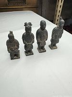 Front view of four black terracotta warrior figurines