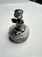 Front view showing kneeling angel figure on round box