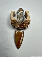 Front view showing jasper cabochon, fossil wood, and overall pendant design