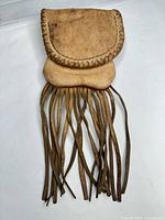 Front view of entire leather pouch with fringe