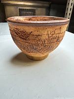 Angled view showing exterior carving, footed base, overall form