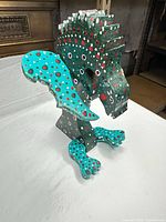 Front angle of wooden folk art sculpture showing teal and polka-dot finish