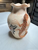 front view showing ruffled rim, one orange lizard and painted motif