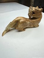 Right side view of the stone guardian lion showing overall form and coloration