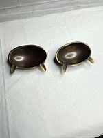 Pair of oval brass tripod dishes on surface