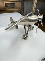 angled side view showing entire airplane, wheels, propeller