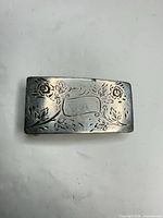 Front view showing engraved floral design and overall shape