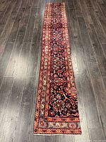 Full view of entire Persian runner rug on dark wood floor