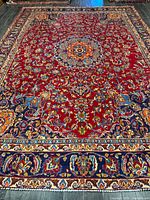 Full view of entire red field Persian rug showing central medallion and borders