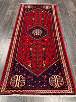 Full view of Persian rug showing entire design, fringe ends visible