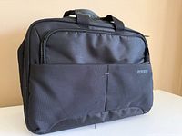 Front view of black American Tourister Speedair carry-on bag showing exterior pockets and handles