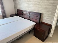 Wide view of headboard and right nightstand with mattresses