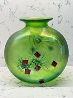 Front view of green iridescent Robert Held vase showing red square inclusions