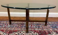 Full view of coffee table showing oval glass top on brass base