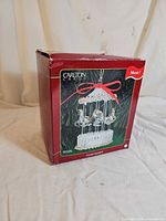 Front view of red box showing product image of crystal carousel ornament