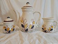 Full set: teapot, sugar jar, creamer showing front leaf motif