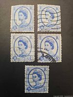 Front view of five cancelled 4d blue QEII Wilding stamps