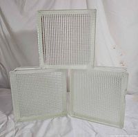 Front view of three glass blocks showing grid texture