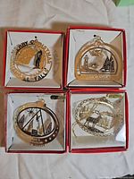 Group shot of four boxed gold-finish brass ornaments