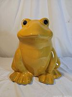 Front view showing full frog figurine, yellow glaze and eyes