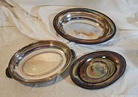 Three silver-plated oval platters grouped together