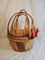 all four nested wicker baskets showing rooster-head handles