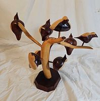 Front view of two-tone wood branch sculpture with eight birds