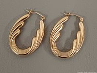 Front view of both gold oval hoop earrings
