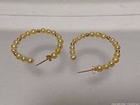 Front view showing both hoops with pearls and gold beads