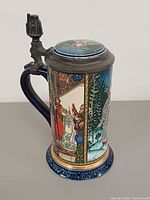 Full view showing stein body, handle, pewter lid and artwork