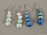 Front view of both earring pairs showing pearl colors and arrangement