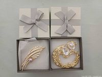 Both brooches in gift boxes