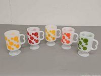 Front view of five pedestal mugs showing colours and pattern