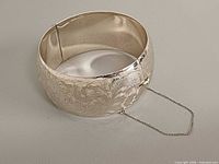 Front view showing floral engraving and safety chain