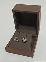 Both knot stud earrings in open Birks box