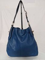 Front view of blue leather Coach hobo bag showing overall shape, strap and hardware