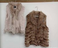 Front view of both rabbit fur vests on hangers